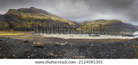 Panoramic view of hills around Svinafellsjokull glacier in southern Iceland, floating ice in the lake, overcast sky 