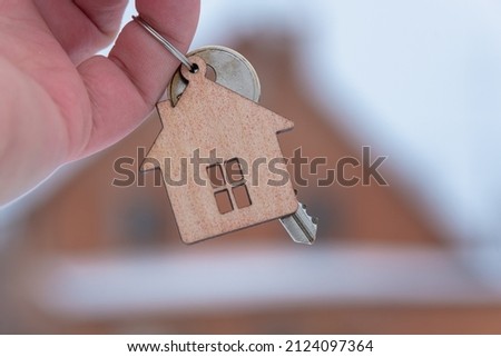 Keys with a keychain on the background of the house.