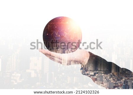 Double exposure of hand holding globe with growing light with city scape for global business concept,Element of this image from NASA 