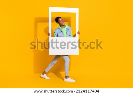 Full length body size view of attractive cheery funky girl holding frame having fun good mood isolated over bright yellow color background Royalty-Free Stock Photo #2124117404