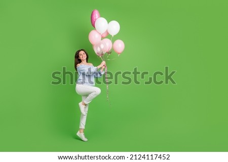 Full size photo of cute good mood female receive birthday present cute pink balloons isolated on green color background