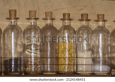 wooden shelving with glass bottles with spices inside