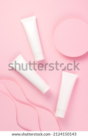 Concept beauty, care, treatment. Set with cream tube and paper sun and waves on pink background, vertical, flatlay