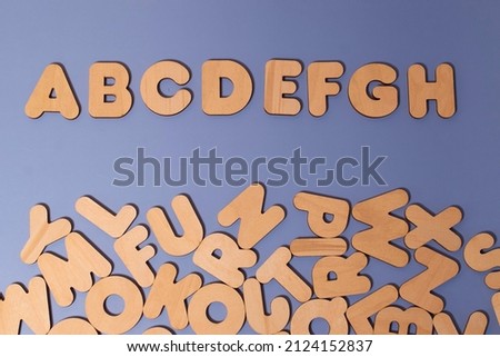 A set of wooden letters of the English alphabet on a colored background, empty space
