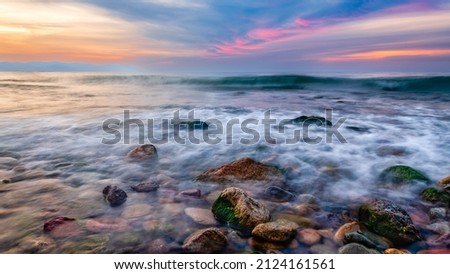 An Ocean Landscape With Sea rocks In The Foreground And A Colorful Sunset Sky Overhead High Resolution 16.9 Image Format Royalty-Free Stock Photo #2124161561