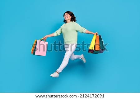 Full body photo of funny young brunette lady go shoping wear shirt pants sneakers isolated on blue background Royalty-Free Stock Photo #2124172091