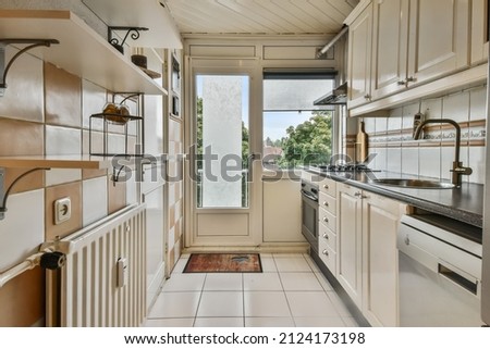 Small kitchen with white tiles on the wall Royalty-Free Stock Photo #2124173198