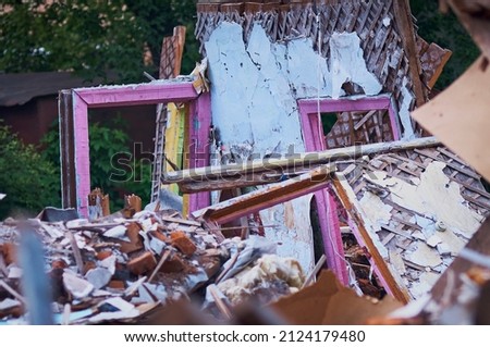 Ruins of a destroyed wooden house. Fragments of walls, boards, interior details. Summer sunny day. Selective focus.