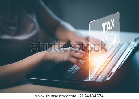 Hand using tablet with bar  TAX REFUND and refund tax of duty taxation business, graphs and chart being demonstrated on the screen media,  tablet pc and selecting tax refund. Royalty-Free Stock Photo #2124184574