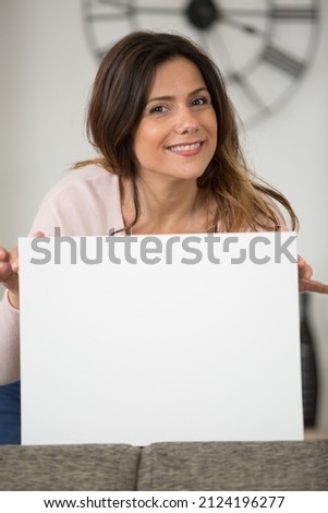 happy woman looking at camera pointing at banner