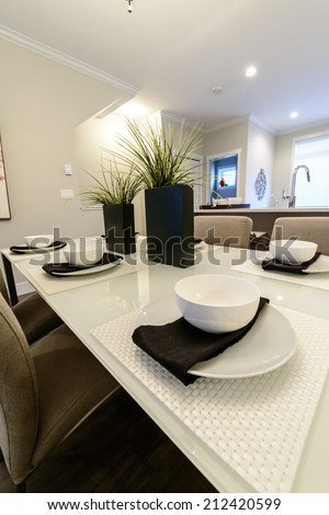 Nicely decorated dining table with cups, plates and napkins. Interior design. Vertical.
