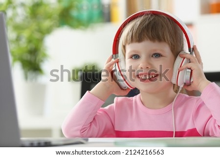 Little happy girl wearing headset, fun pastime for child on holiday