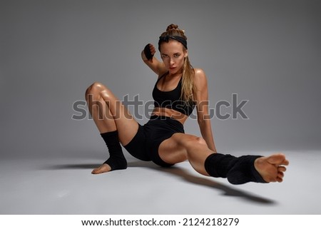 Portrait of female anger, animal instinct, demonstrating their incredible flexibility with the movement of animal flow in the studio on a gray background.