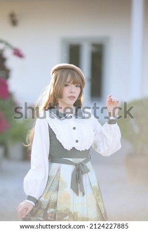 A beautiful woman in lolita dress in garden background Japanese street fashion portrait