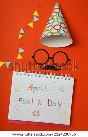 Concept of April Fool's Day on orange background