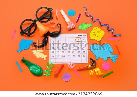 Calendar with marked date of April Fools Day and different party decor on color background Royalty-Free Stock Photo #2124239066