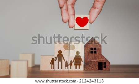 Idea of adding love and warmth to the family. Hand holding wooden cube block with red heart icon for family.
