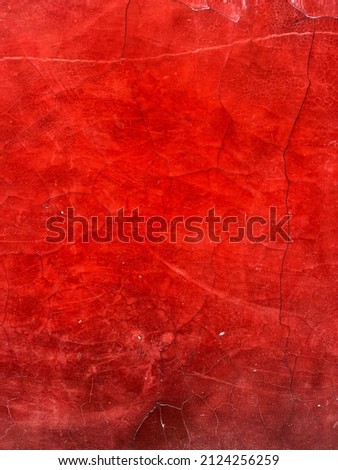 Old worn red wall surface with cracked pattern as background and graphic design element