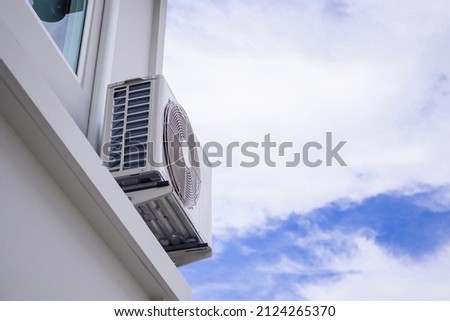 Air condition outdoor unit compressor install outside the house with blue sky Royalty-Free Stock Photo #2124265370