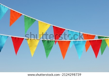 Buntings with colorful triangular flags against blue sky Royalty-Free Stock Photo #2124298739