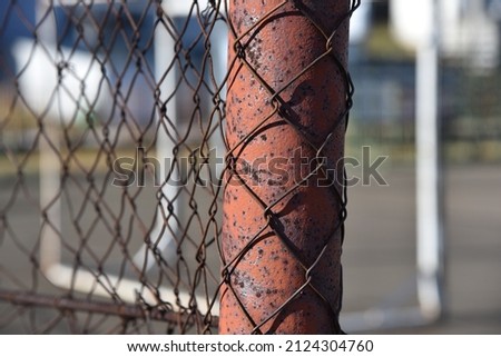 A close up of an old wired fence on the football court.