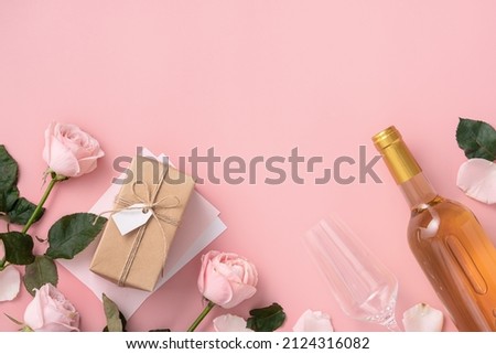 Top view of Valentine's Day gift with wine and pink rose bouquet on pink background design concept Royalty-Free Stock Photo #2124316082
