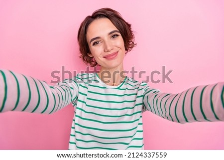 Self-portrait of attractive cheery funny brunette girl good mood posing isolated over pink pastel color background