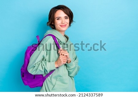 Photo of sweet adorable woman wear green sweatshirt rucksack walking empty space isolated blue color background