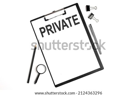 On a white background magnifier, a pen and a sheet of paper with text PRIVATE Business concept
