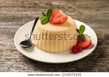 Delicious semolina pudding with berries on wooden table Royalty-Free Stock Photo #2124372245