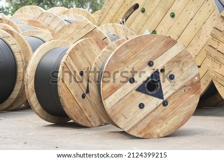 Wooden Coils Of Electric Cable Outdoor. High and low voltage cables in the storage. Royalty-Free Stock Photo #2124399215