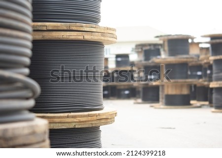 Wooden Coils Of Electric Cable Outdoor. High and low voltage cables in the storage. Royalty-Free Stock Photo #2124399218