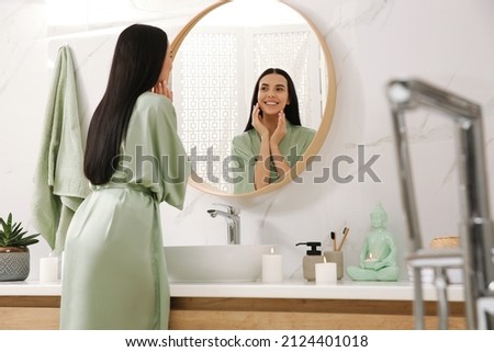 Beautiful young woman near mirror in bathroom Royalty-Free Stock Photo #2124401018