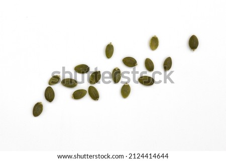 heap of green pumpkin seeds isolated on white background, scattered raw peeled seeds, top view Royalty-Free Stock Photo #2124414644