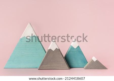 Colored mountains of wood on a pink background, children's toys or decorative items