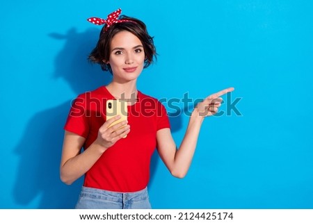 Photo of young lady indicate finger empty space ads recommend suggest app subscribe isolated over blue color background
