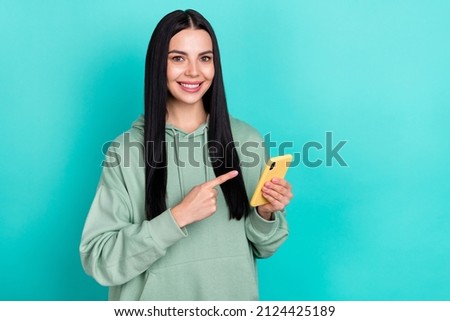 Photo of sweet young brunette lady index telephone wear green hoodie isolated on turquoise color background