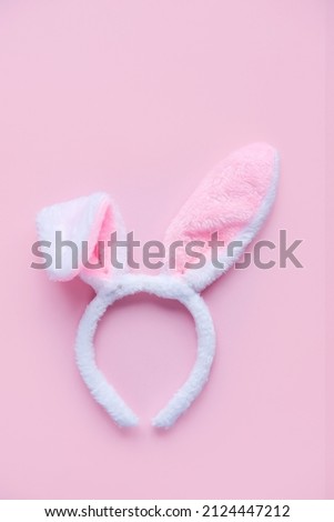 Fluffy pink ears of an Easter bunny on a pink background. Flat lay, place for text. Vertical image.