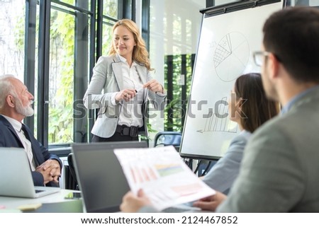 Successful business woman presenting new business strategy to partners in office