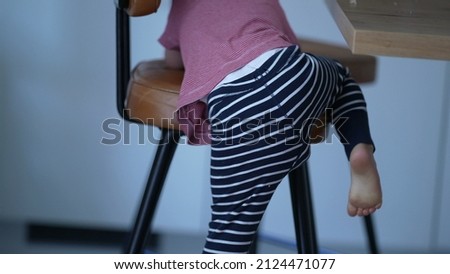 Little boy climbing high-chair child climbs chair