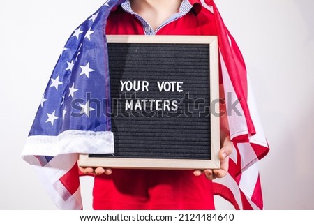 kid boy with american flag holding letter board with text Your Vote Matters on white background