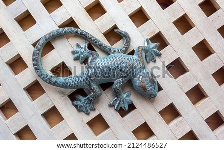 Decorative green lizard made of stone on wooden boards.