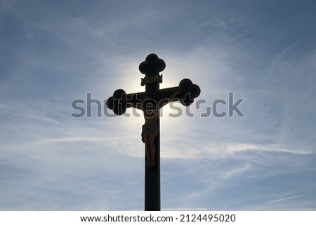 Cross with Jesus christ backlighted by the sun