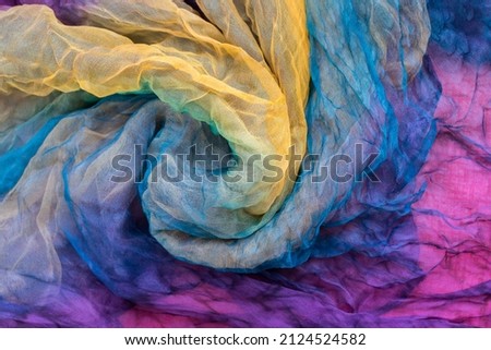 Photo of fabric dyed in different colors and laid out in an abstract form, to be used as a backdrop