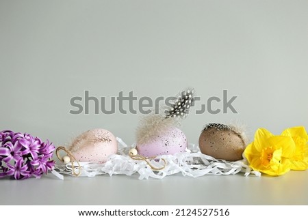Decorative Easter colorful eggs with spring flowers on light pastel background. Selective focus