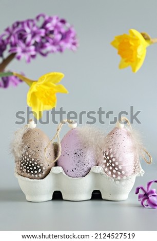 Decorative Easter Chicken eggs with spring flowers on light pastel background. Selective focus