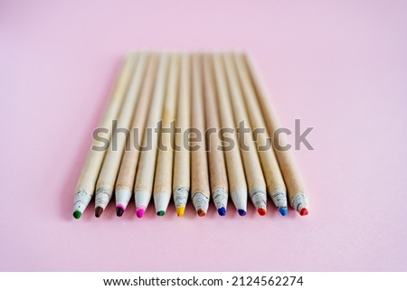 A set of pencils lies on a pink background. Draw and create. natural pencils made of wood for children. Bright colors in the set. High quality photo