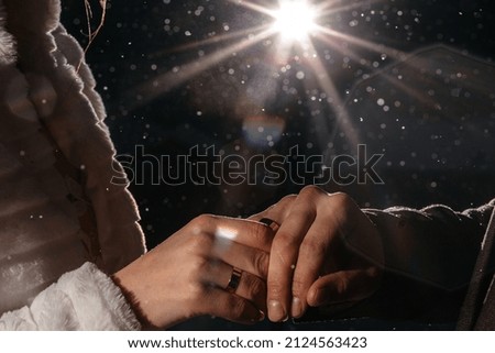 hands with rings at night