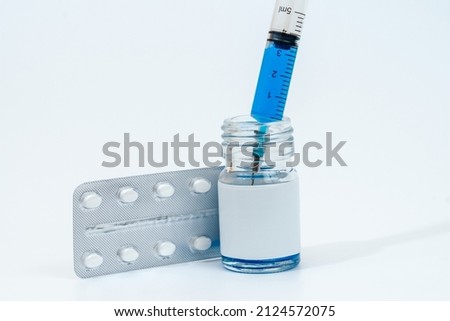 Medical glass bottle with syringe and tablets (pills) isolated on white background