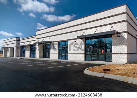 Horizontal shot of new retail strip shopping center with under construction. Royalty-Free Stock Photo #2124608438